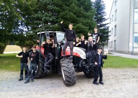 Schler:innen am Parkplatz der Schule auf und rund einem Steyr-Traktor